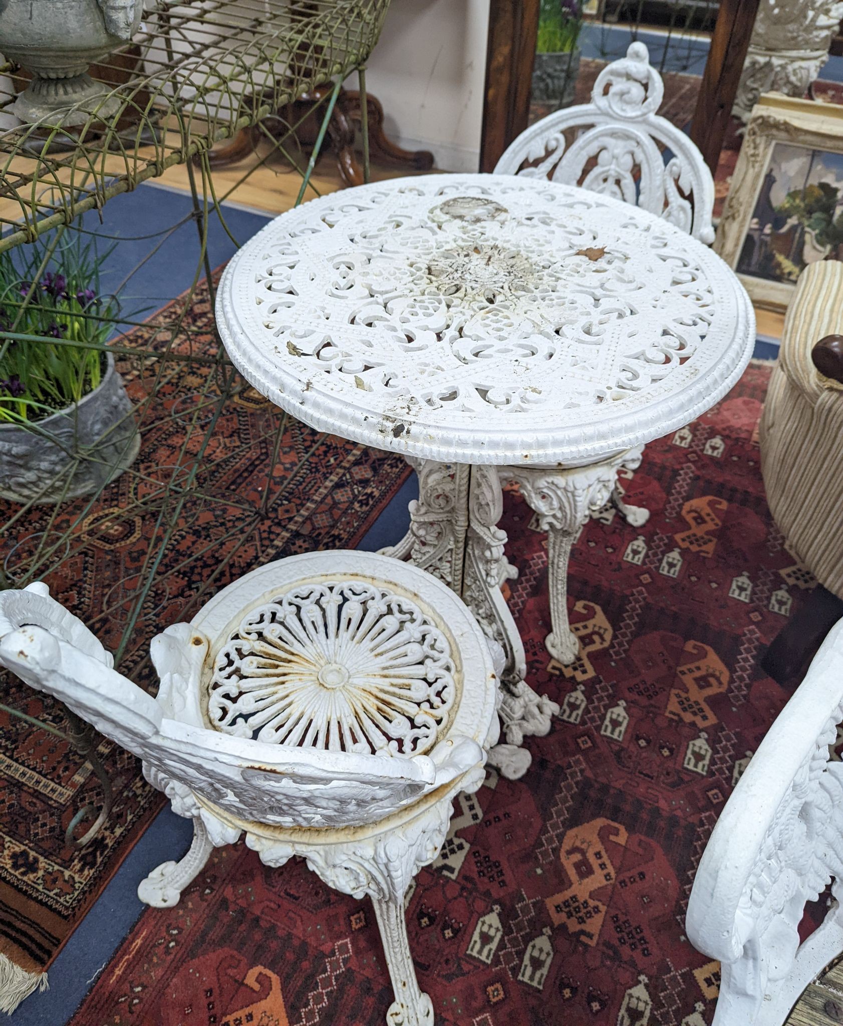 A Victorian Coalbrookdale style painted cast iron garden table, diameter 58cm, height 70cm and pair of chairs